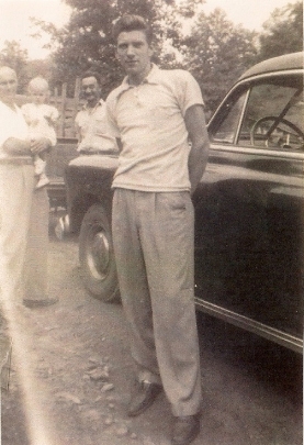 1900s Larry posing by his car, daughter in the background.jpg